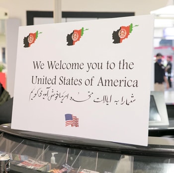 Un cartel de bienvenida en inglés y darí en Washington Dulles International Airport