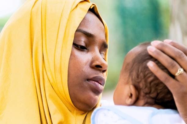 Black muslim mother holding her baby