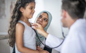 doctor screening refugee mother and child