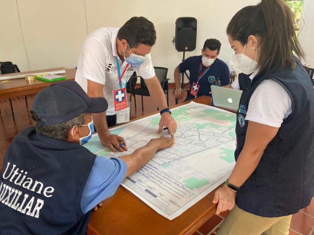 Colombian public health officials looking at a map