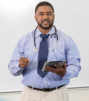 man with stethoscope holds a tablet and points
