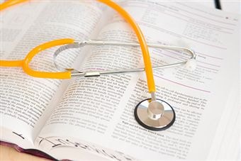 A stethoscope placed on top of an open book