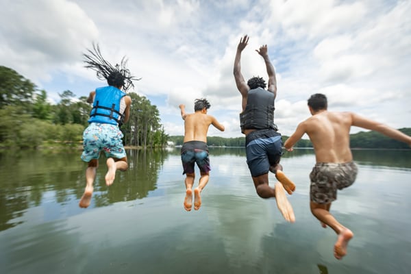 people jumping in pond