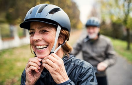 Image of a woman adjusting her bike helmet