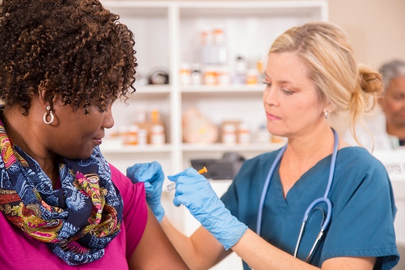 enfermera dando vacuna contra la gripe