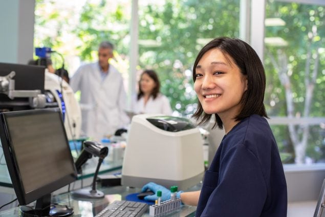 Smiling technician working in clinical laboratory