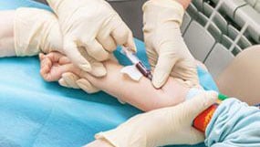 A healthcare provider taking a blood sample from a patient's vein to find the blood lead level.