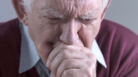 An older man coughing