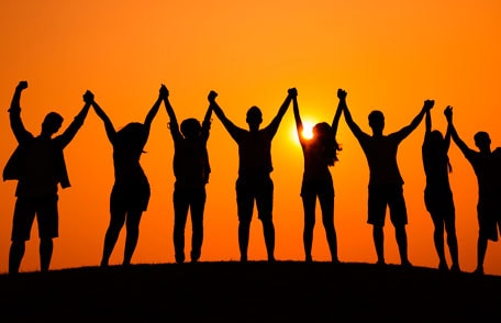 Silhouette of people holding and lifting hands