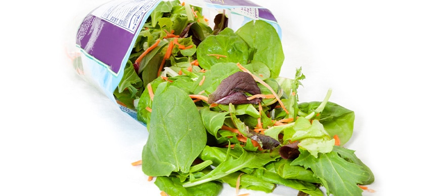 Packaged salad mix over a white background