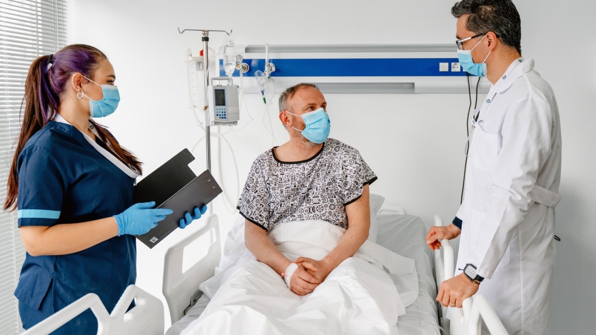 Foto de un paciente con cáncer colorrectal en un hospital hablando con su médico y su enfermera