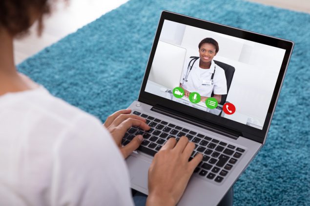 Woman Video Conferencing With Doctor On Laptop