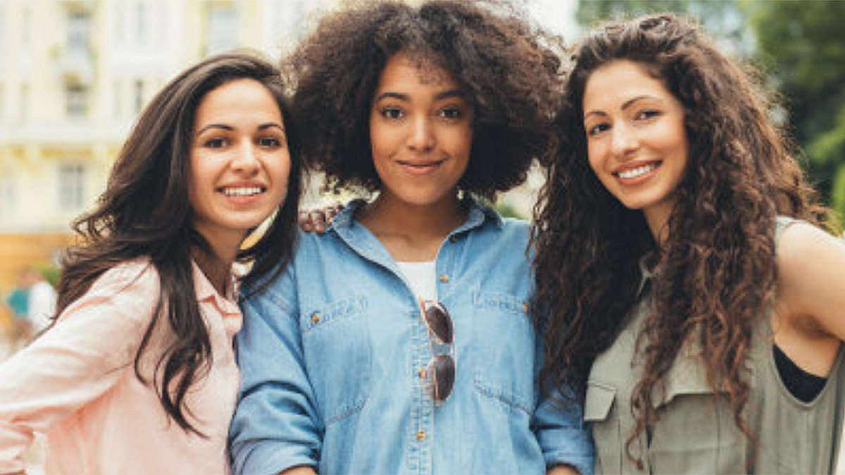 Three young women posing outdoors.