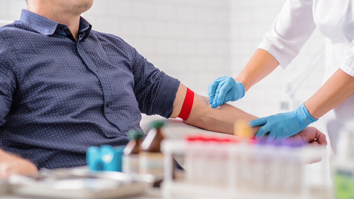 A HCP prepares a patient for a blood sample.