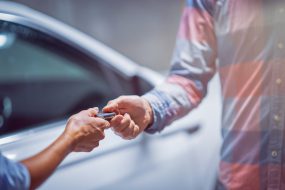 Car dealer giving keys to a customer