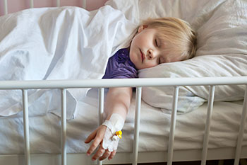 sick-child-iv Sick child laying in bed with an IV