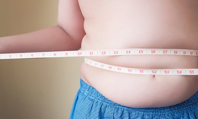 overweight child measuring stomach