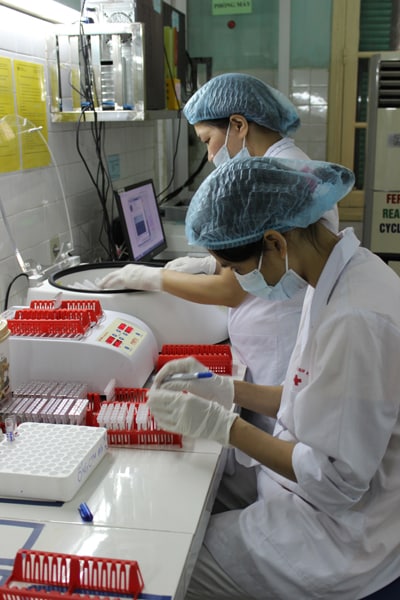 Lab workers in Vietnam run diagnostic tests.