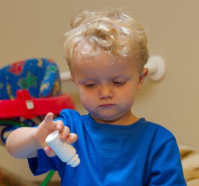 child playing with medicine bottle