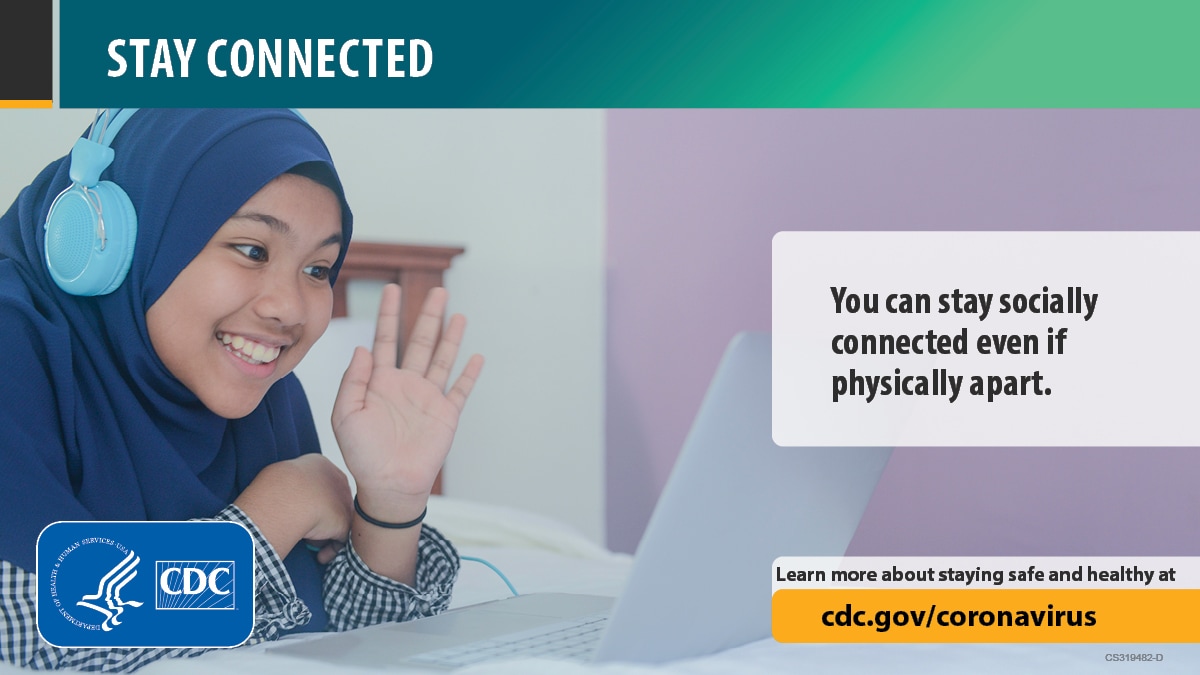Happy young female wearing a hijab in front of a laptop