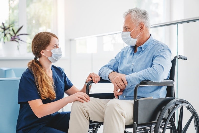 health worker talking with man in wheelchair