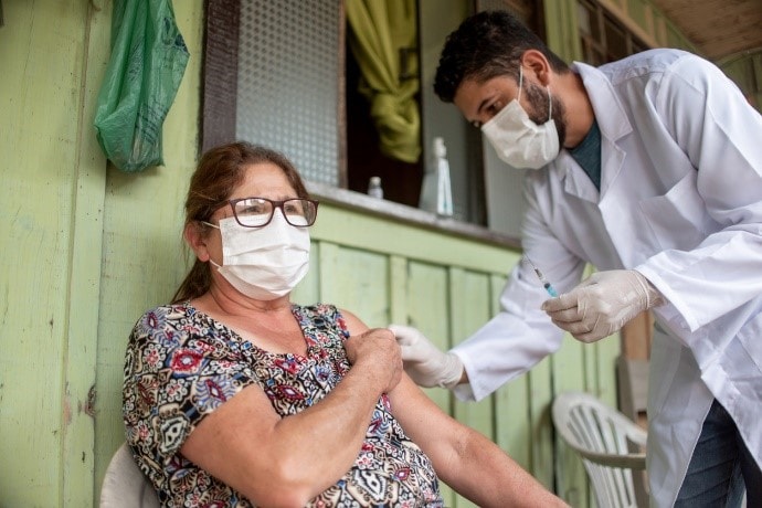 woman receiving vaccination from health worker