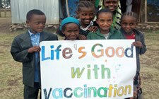  The figure above is a photograph showing children holding a sign reading: â€œLifeâ€™s good with vaccinationâ€ in commemoration of CDCâ€™s 50 years of global immunization efforts.