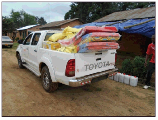 The figure above is a photograph of a truck transporting solidarity kits containing essential supplies for Ebola survivors returning home in Firestone District, Liberia in 2014.