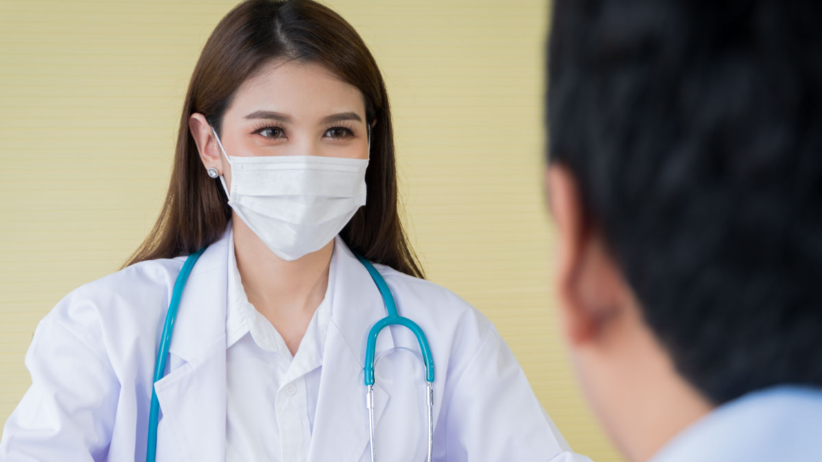 The figure is a photo of a health care provider wearing a mask and talking to someone.