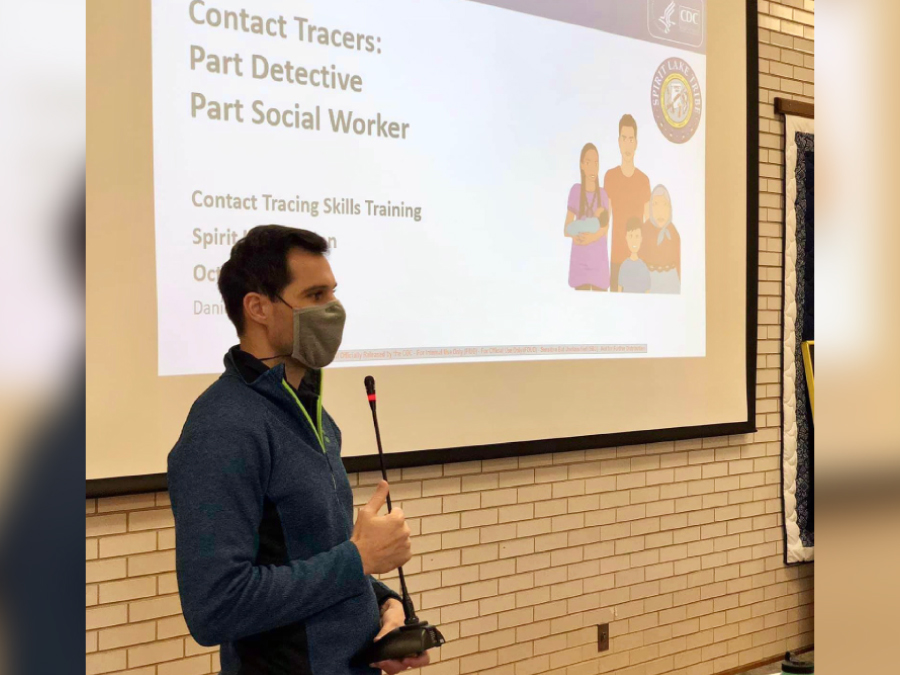 Notes from the Field: COVID-19 Case Investigation and Contact Tracing Program — Spirit Lake Tribe, North Dakota, September–November 2020 The figure is a photo of a man wearing a mask giving a presentation on contact tracing.