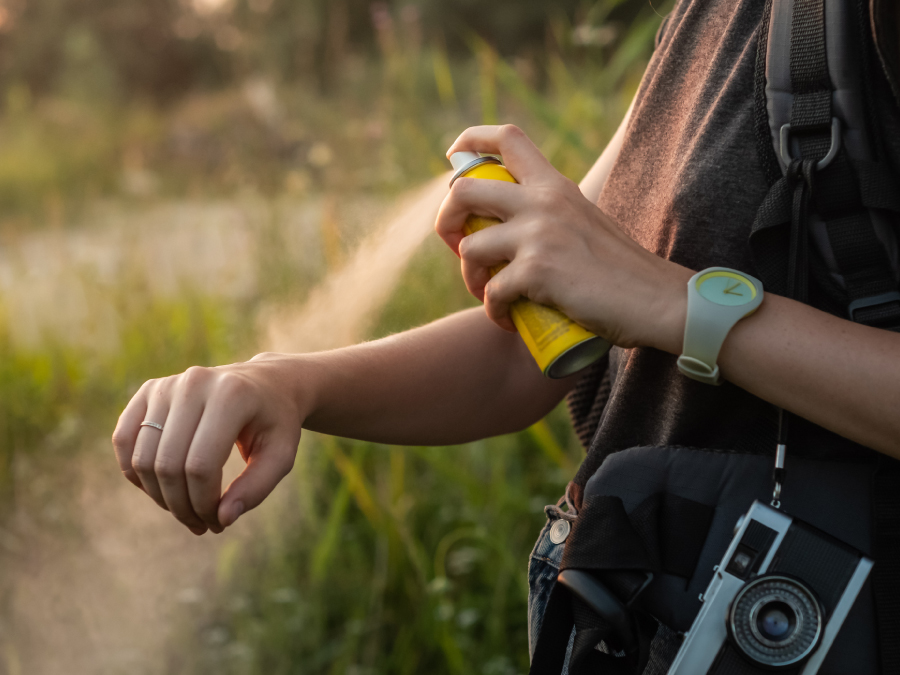 The figure is a photo of a person applying bug repellent.