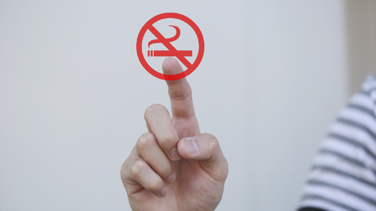 The image shows a hand pointing to a “No Smoking” symbol.