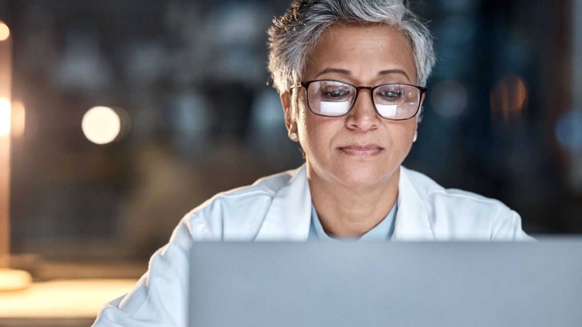 The image shows a health care provider on a computer.