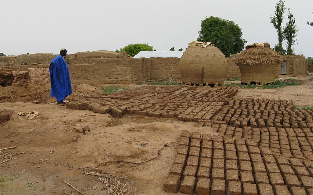 A village man is making bricks from mud.