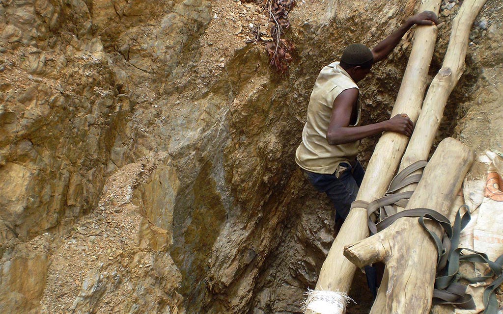 A village man climbing into a mine.