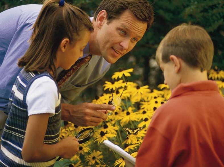 A teacher talks to kids about the flowers.