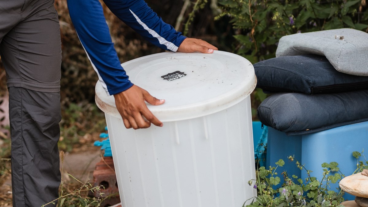 Photo of a person covering a water-holding container.