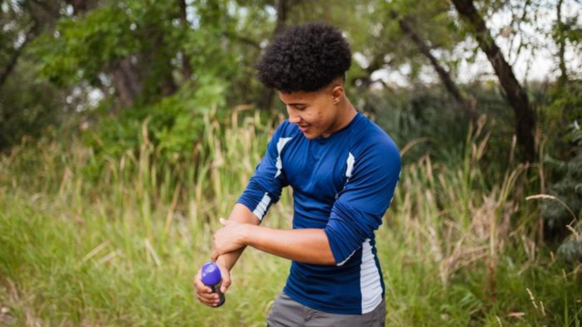 Person applying insect repellent.