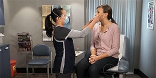 Healthcare provider taking a buccal swab from a patient.