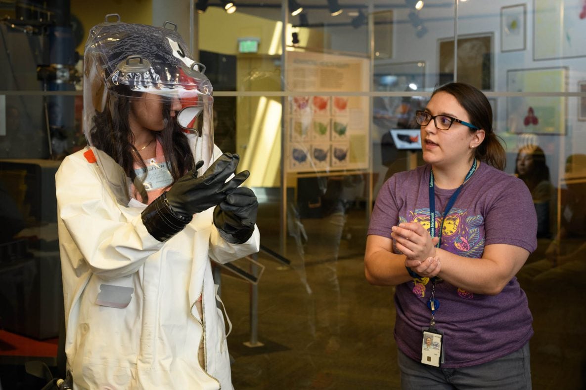 Student trying on biosafety laboratory suit