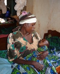 Mother cradling sick child in her arms, Tanzania (Courtesy UNHCR Malaria Team).