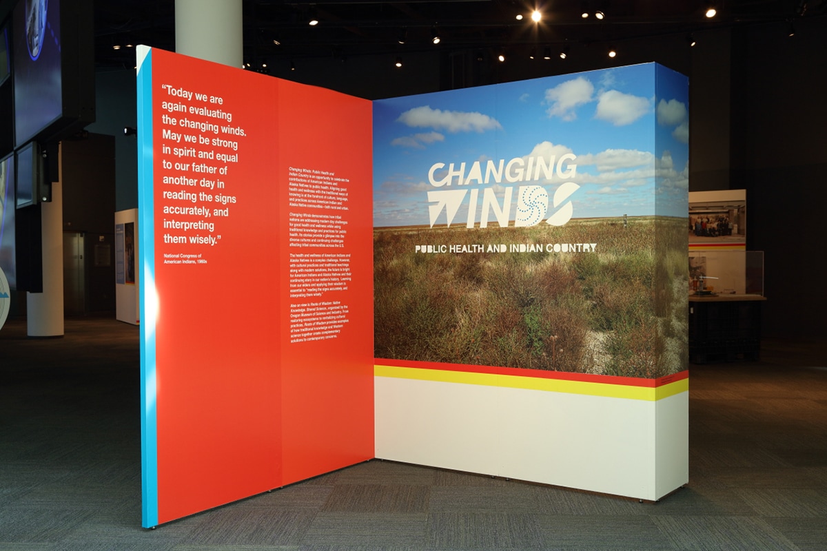 Left wall is red wall with white text. Right wall is a large image of the sky and plains.