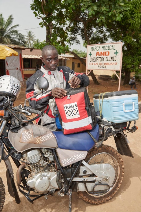 A motorcycle courier preparing his backpack before travel.