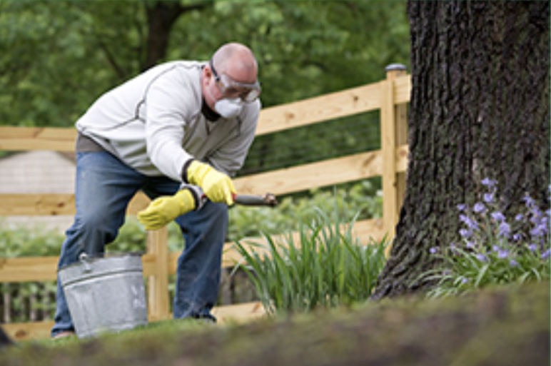 phapproach04 A man working outdoors wearing rubber gloves, goggles, and a mask