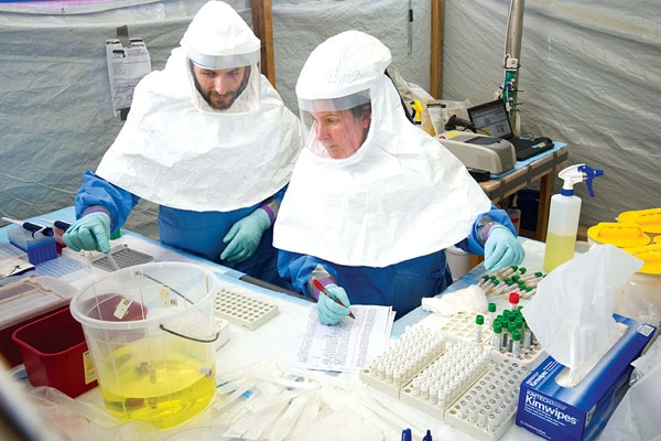 Photo of people wearing protective attire while testing Ebola samples