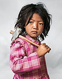 Photograph of a Nepalese child holding a hammer