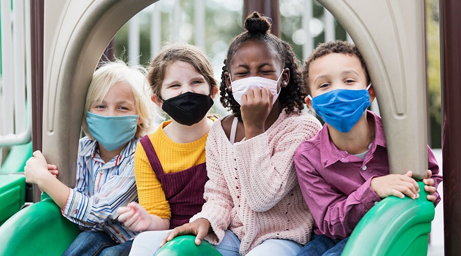 Children wearing protective face masks on the playground