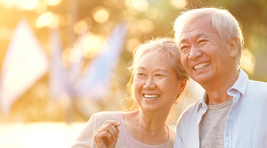 A senior Asian couple in the park at sunset