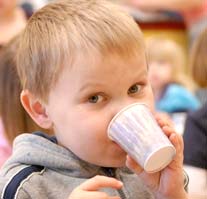 A young boy drinking from a cup