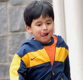 A little boy running with his tongue out